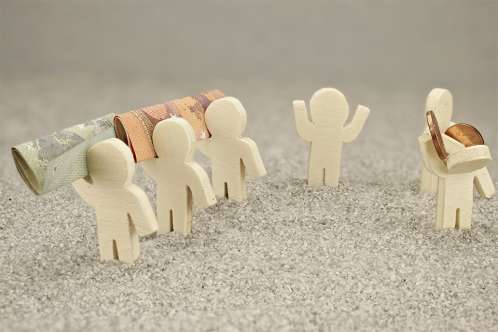 Foto: Kleine Figuren mit Geldscheinen und Münzen